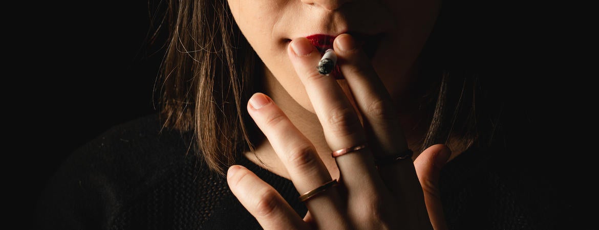 A young woman smokes a cigarette